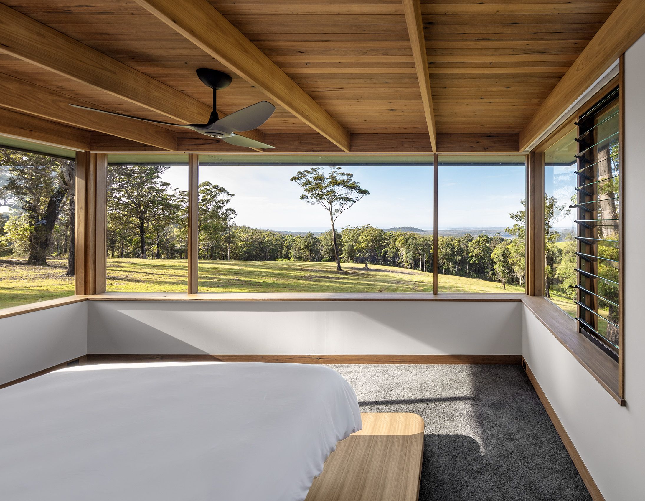 Bedroom with a corner window looking into the gum trees
