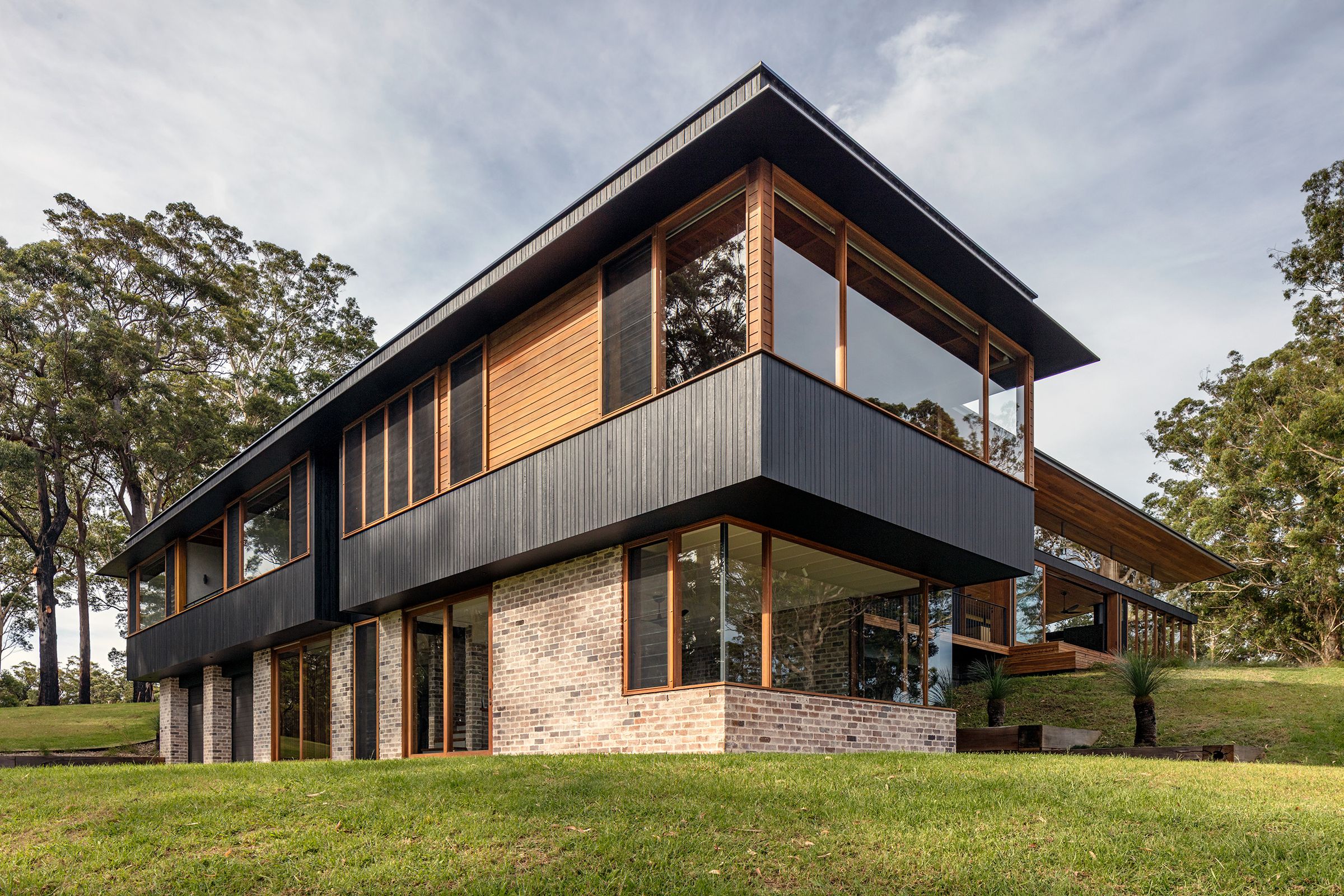 The house stepping down its lawn among spotted gums