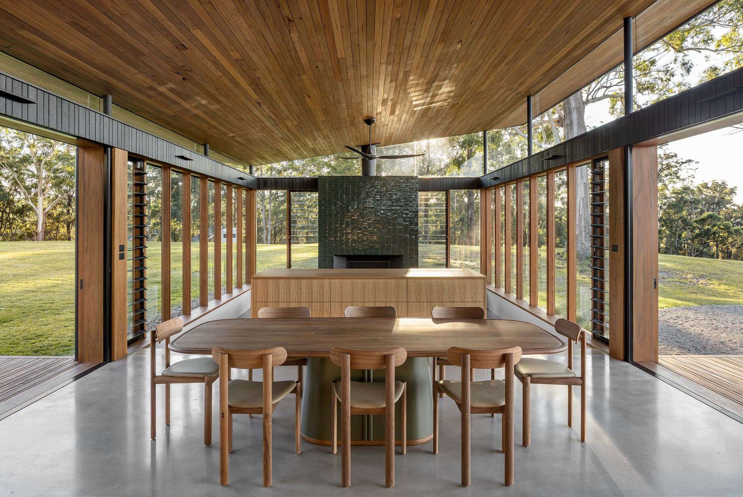 Dining table under a timber ceiling, open to the deck