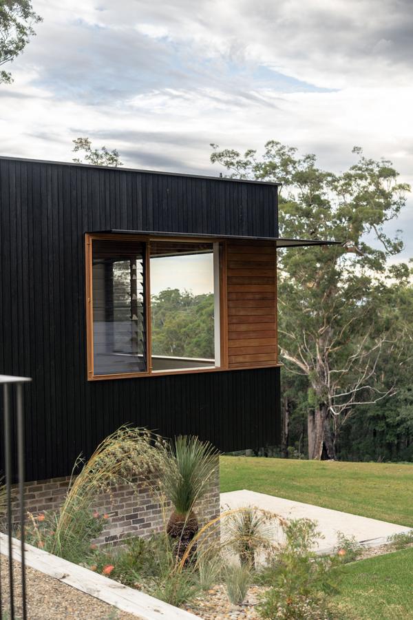 The charcoal bedroom wing among the gums