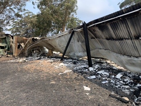 A collapsed roof and ash where the original buildings stood